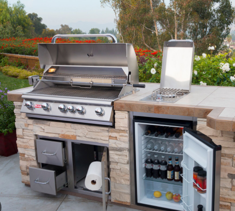 Brahma 38" 5-burner stainless steel grill with heavy duty cart featuring double doors, side shelves, and locking casters in an outdoor kitchen setup