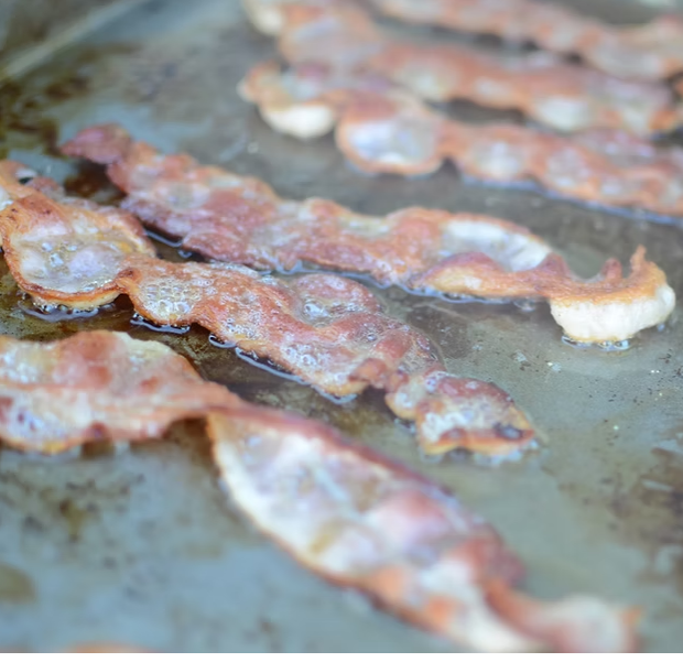 Kokomo BBQ Grill Griddle cooking crispy bacon on stainless steel griddle plate insert