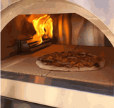 Traditional 25-inch dual fueled wood and gas pizza oven with blazing fire and pizza inside
