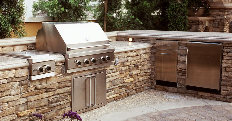 High-end outdoor BBQ grills set up in a backyard outdoor kitchen